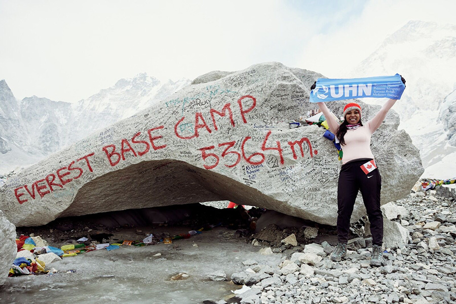 Anet at Everest Base Camp holding UHN sign 